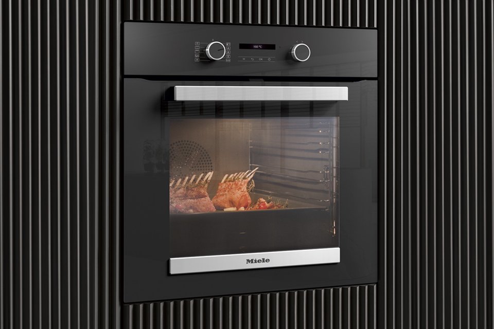 Close up of Miele built in oven with meat ribs cooking inside.